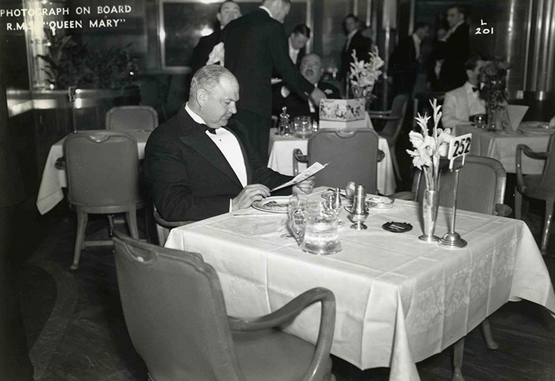 M. Édouard Simard attablé au restaurant à bord du navire <em>Queen Mary.</em>
