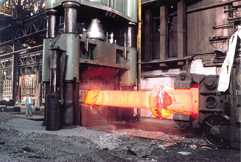 Un homme près d'un lingot rougeoyant à l'intérieur de l'usine.