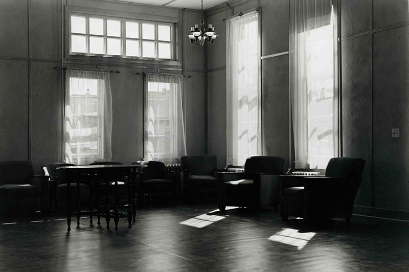 Plusieurs fauteuils et une table dans une grande salle vitrée