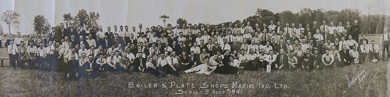 Plusieurs travailleurs posant sur la pelouse.