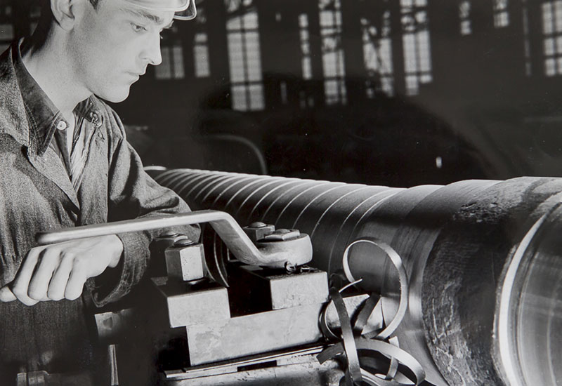 Un jeune homme examine une pièce métallique.