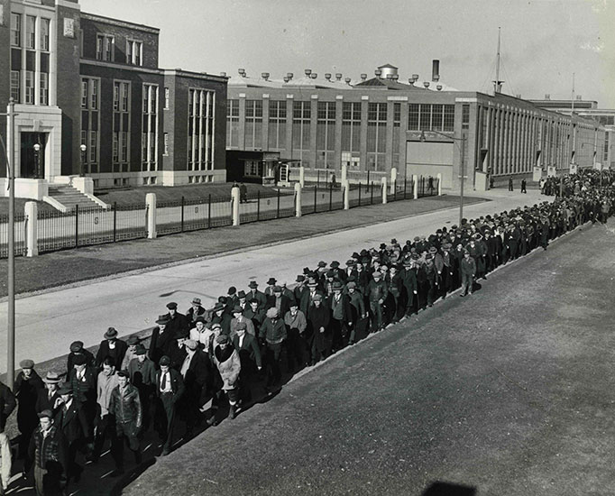 Un grand nombre de travailleurs sortent de l'usine.