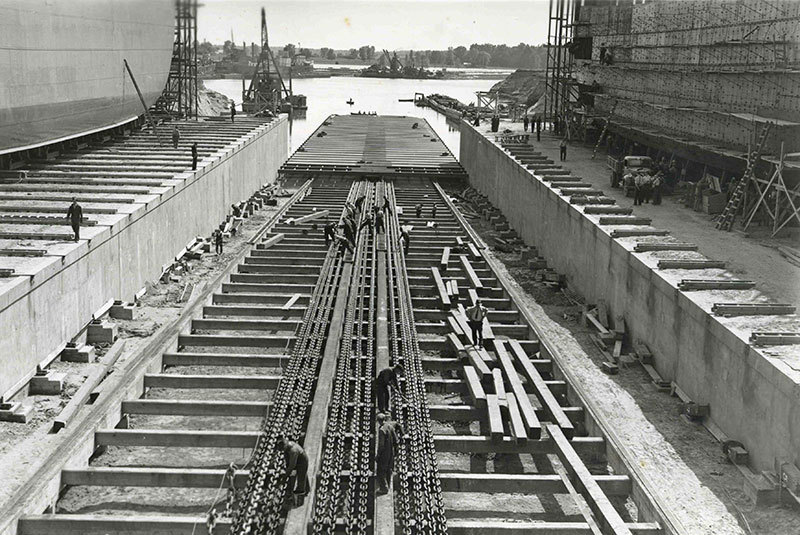 Plusieurs hommes travaillent sur la rampe de lancement des bateaux.