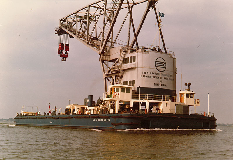 On voit la grue flottante sur l'eau du fleuve.