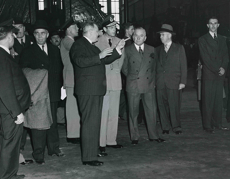 Plusieurs hommes discutant à l'intérieur de l'usine.