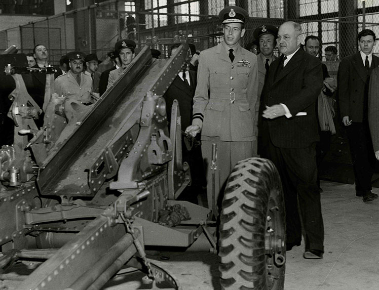 Plusieurs hommes parlant devant un canon de 25 livres.