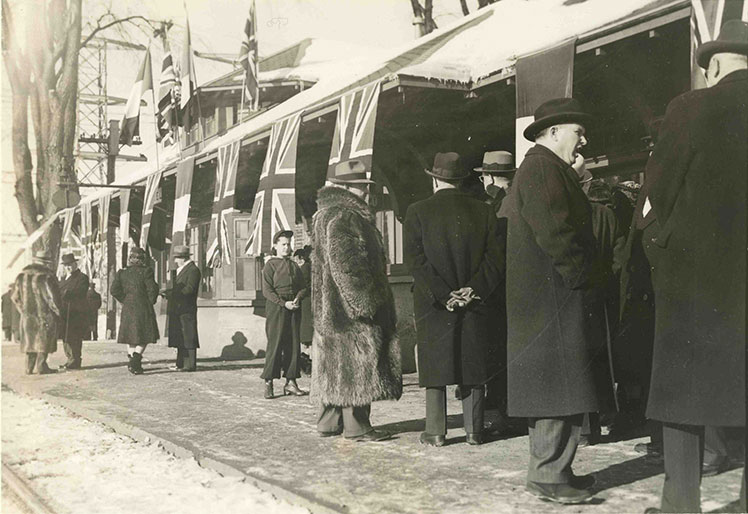 Plusieurs personnes près d'un train décoré de drapeaux.