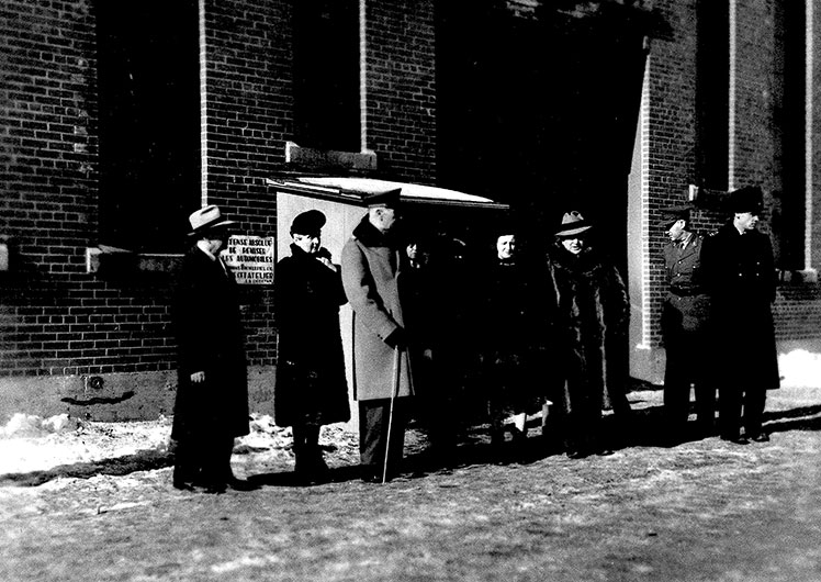 Deux femmes et six hommes devant une usine en briques