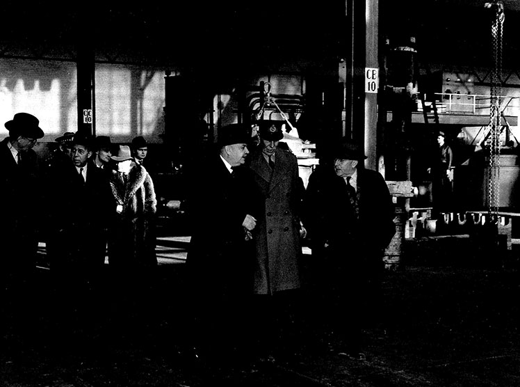 Plusieurs hommes circulent à l'intérieur d'une usine.