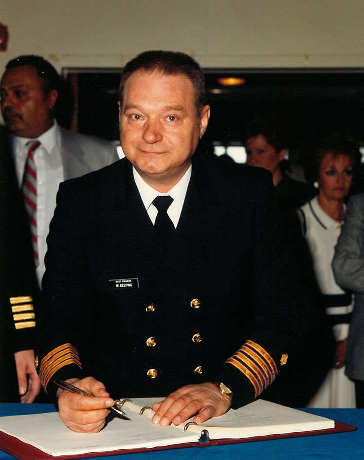 Un homme en uniforme signant un livre.