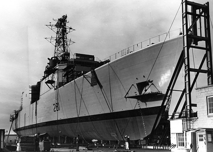 Des hommes à côté d'un destroyer sur la rampe de lancement